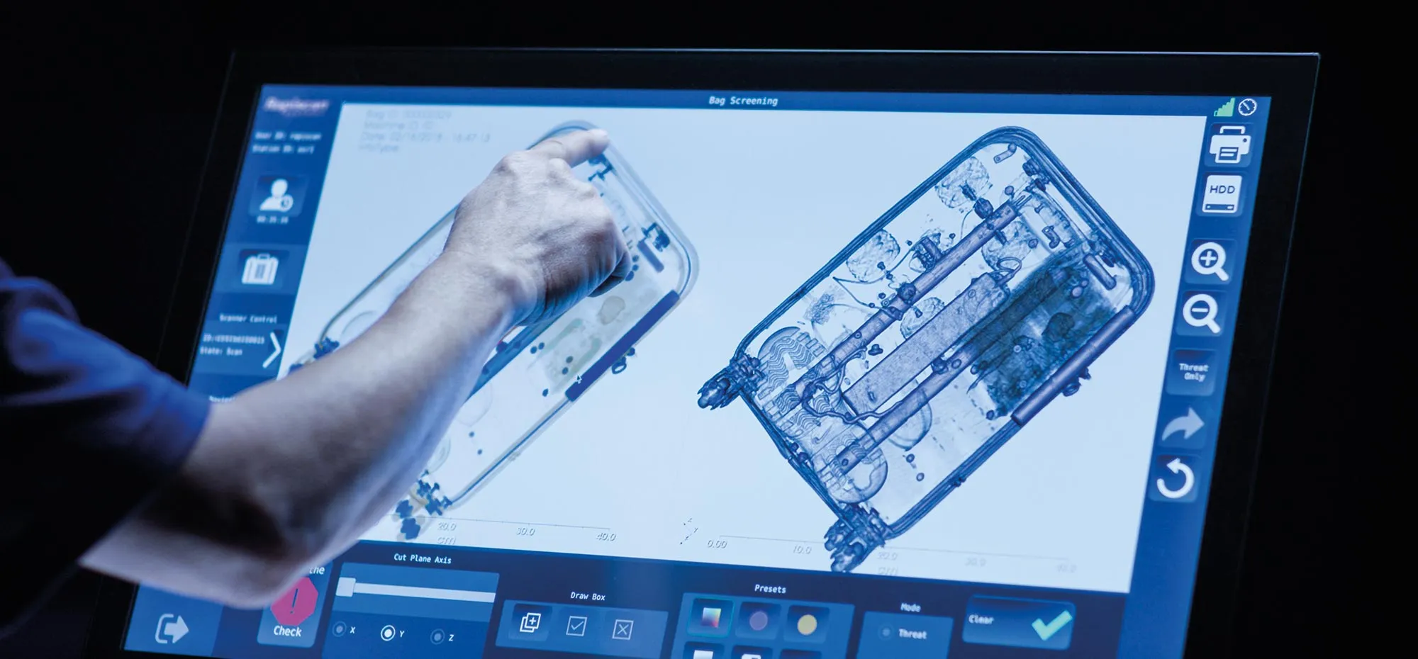 Operator reviewing an X-ray image of a suitcase on the Rapiscan 920CT screen